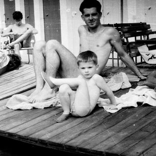 Black and white photo of people on sun loungers.
