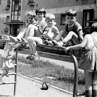 Children playing on a seesaw in a playground.