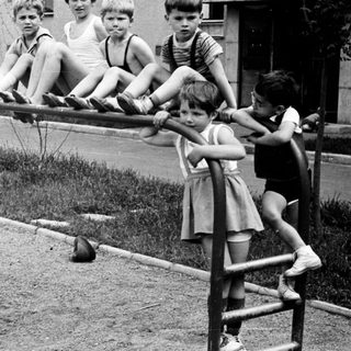 Boys climb on bars; a girl stands below.