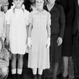 Group portrait of a family standing outside a house.