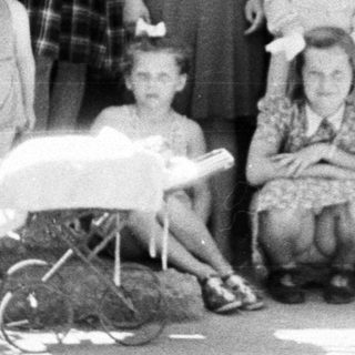 Group portrait of a family standing outside a house.