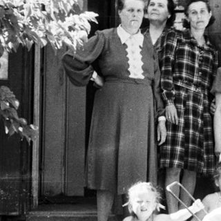 Group portrait of a family standing outside a building.