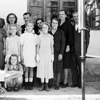 Group portrait of a family standing outside a building.