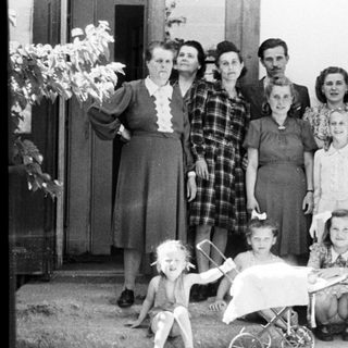 Group portrait of a family standing outside a building.