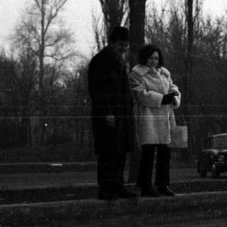 Black and white photo of people in a snowy park.