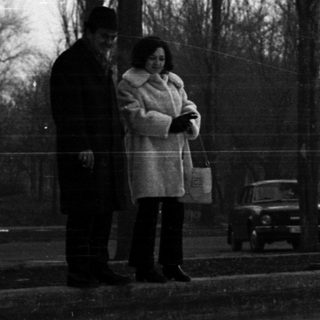 Black and white photo of people in a snowy park.