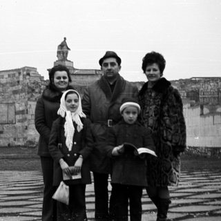 Family portrait with a large wall and monument in background.