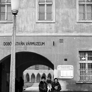 Family stands outside a museum with an arched entrance.