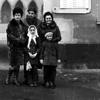 Family stands outside a museum with an arched entrance.