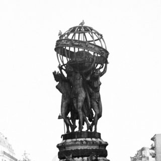 Monumental fountain with statue, reflecting in water, cityscape backdrop.