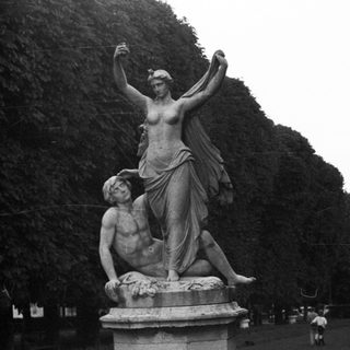 Classical sculpture of a woman standing over a fallen man.