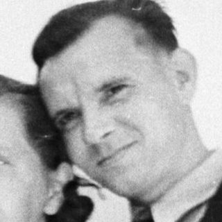A couple poses for a black and white portrait.