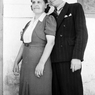 A couple poses for a black and white portrait.