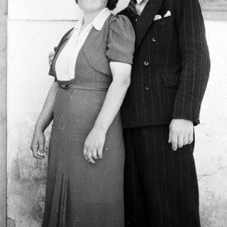A couple poses for a black and white portrait.