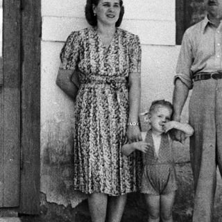 Family portrait of a couple and young child outdoors.