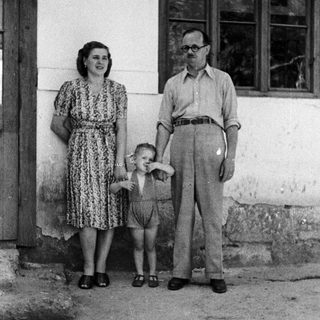Family portrait of a couple and young child outdoors.