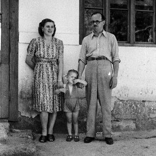 Family portrait of a couple and young child outdoors.