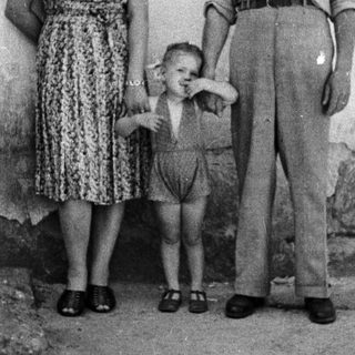 Family portrait of a couple and young child outdoors.