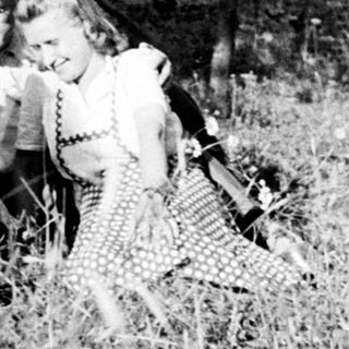 Family portrait outdoors in tall grass, vintage photograph.
