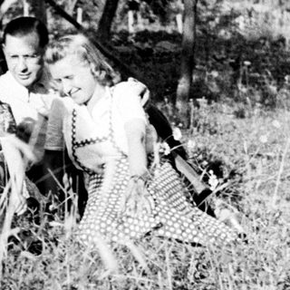 Family portrait outdoors in tall grass, vintage photograph.