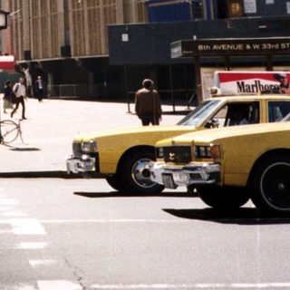 Here's a brief summary of the image: New York City street with the Empire State Building visible.