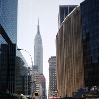 Here's a brief summary of the image: New York City street with the Empire State Building visible.
