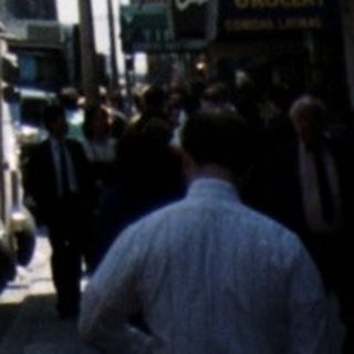 Here's a brief summary of the image: New York City street scene with a tall building in background.