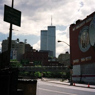 Street scene in Manhattan with a tall building in the distance.