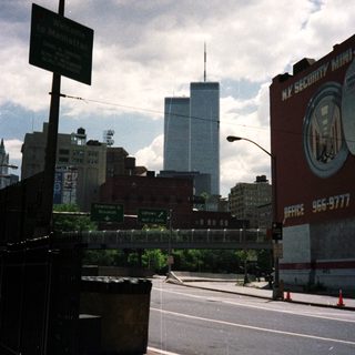 Street scene in Manhattan with a tall building in the distance.