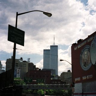 Street scene in Manhattan with a tall building in the distance.