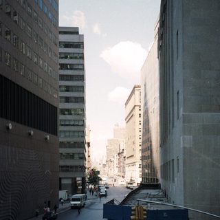 Here's a brief summary of the image: Urban street scene with tall buildings and traffic.