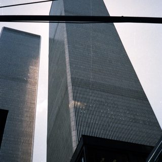 Here's a brief summary of the image: Twin Towers skyscrapers rise against a clear sky.