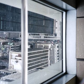 View from a high window overlooking a city skyline.