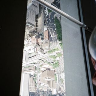 High-angle view of a cityscape seen through an elevator window.