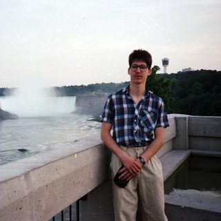 Man poses near Niagara Falls with a view.