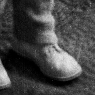 Here's a brief summary of the image: Black and white photo of a young girl in a dress.