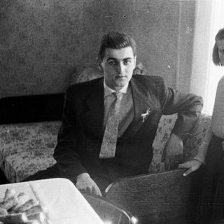 Man and young girl posing indoors in a bedroom.