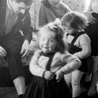 Man interacts with children in a vintage living room.