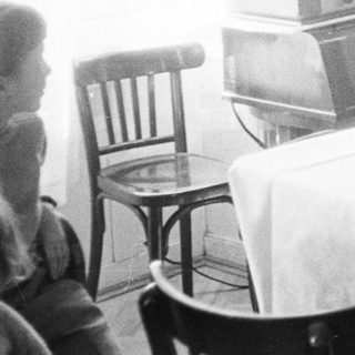 Man and boy at table with food and radio.