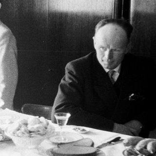 Man and boy at table with food and radio.