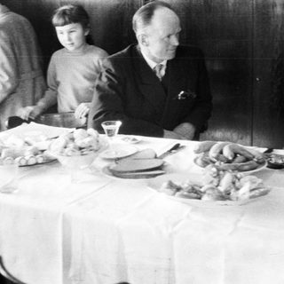Black and white photo of a family at a table.