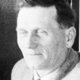 Man seated at a table with food and tableware.