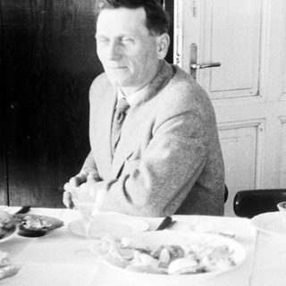 Man seated at a table with food and tableware.