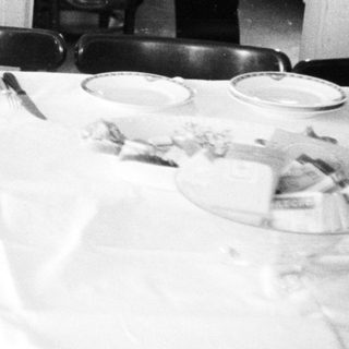 Man seated at a table with food and tableware.