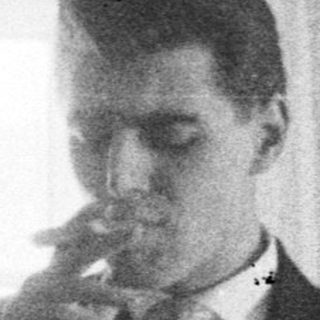 Man smoking in a room, two girls nearby.