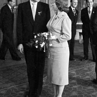 Couple poses with attendants in a formal setting.