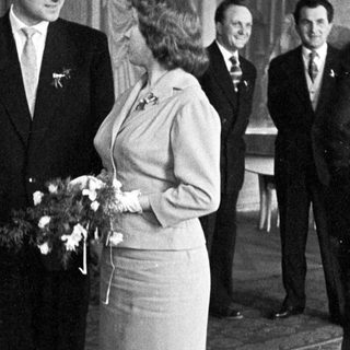 Couple poses with attendants in a formal setting.