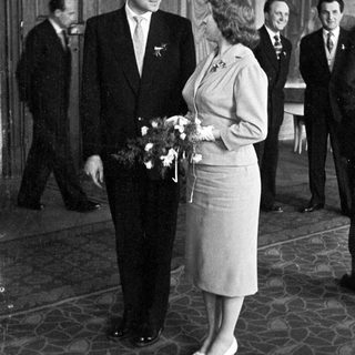 Couple poses with attendants in a formal setting.