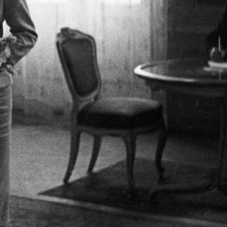 Couple stands near a table in a room.