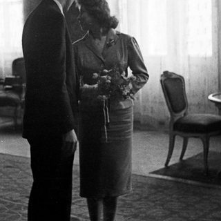 Couple stands near a table in a room.